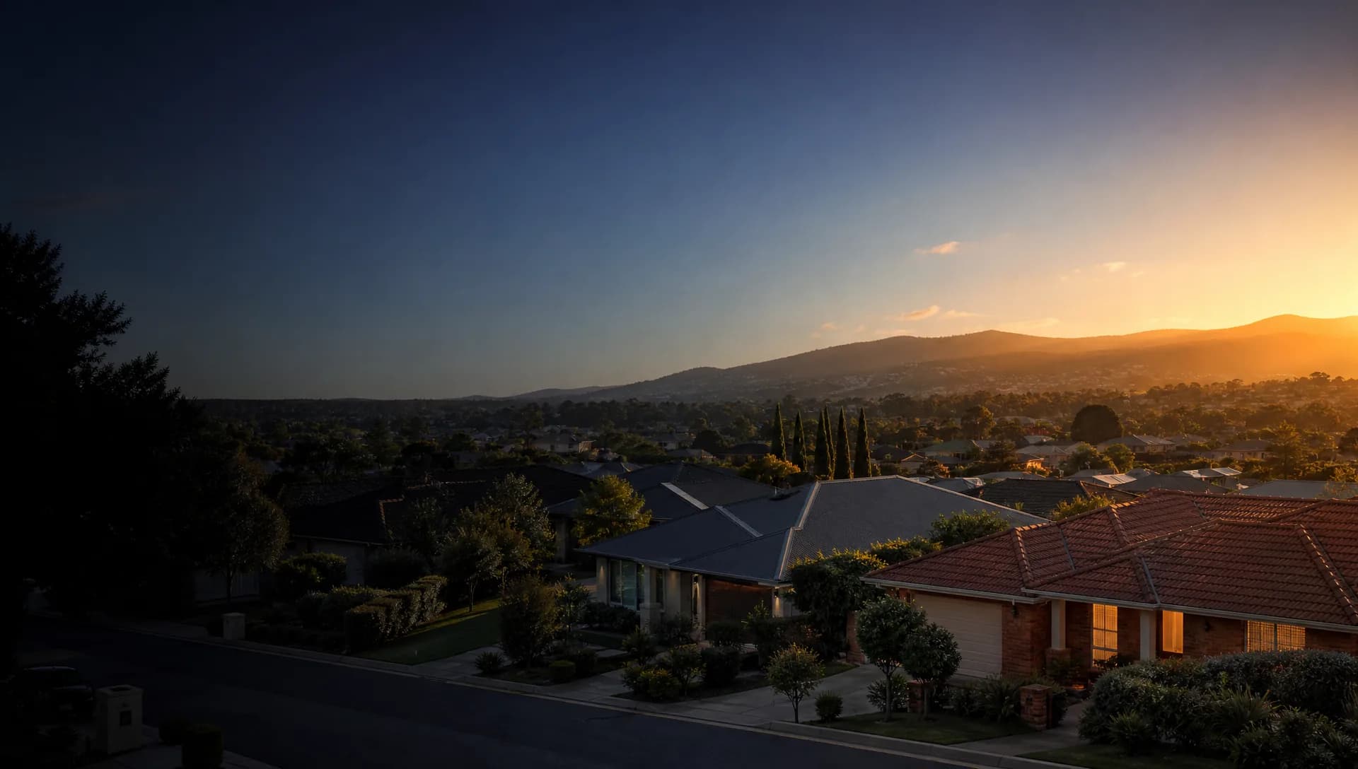 Adelaide suburban rooftops at dusk, with the Adelaide Hills in the distance